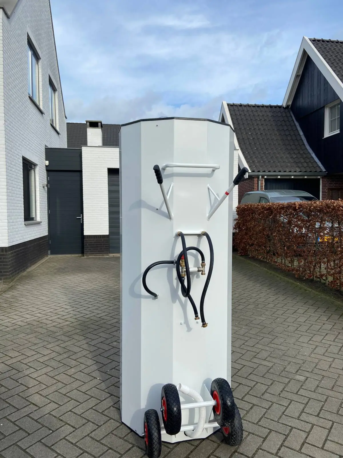 Rückseite der mobilen Duschkabine mit Schläuchen und Transporthilfe
